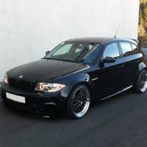 Black BMW 1 series parked against a grey wall. Fitted with the stunning Syvecs BMW 135-335 N54 S7PLUS ecu