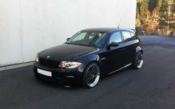 Black BMW 1 series parked against a grey wall. Fitted with the stunning Syvecs BMW 135-335 N54 S7PLUS ecu