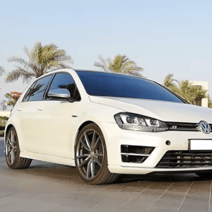 Front view of white VW Golf MK7 with a tropical background and trees, with Syvecs GOLF MK7 R / GTI TSI - S7PLUS ECU