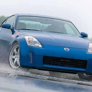 Blue Nissan 350z on a skid pan in the rain with Syvecs Nissan 350Z ECU
