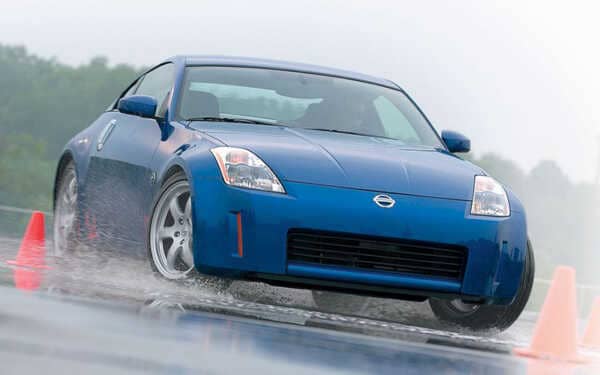 Blue Nissan 350z on a skid pan in the rain with Syvecs Nissan 350Z ECU