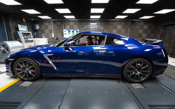 Blue Nissan GTR side view in a grey dyno cell at Hybrid Tune with Syvecs Nissan R35 GTR S7PLUS ECU
