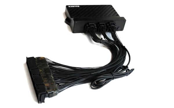 Black syvecs ECU with wiring harness. White background