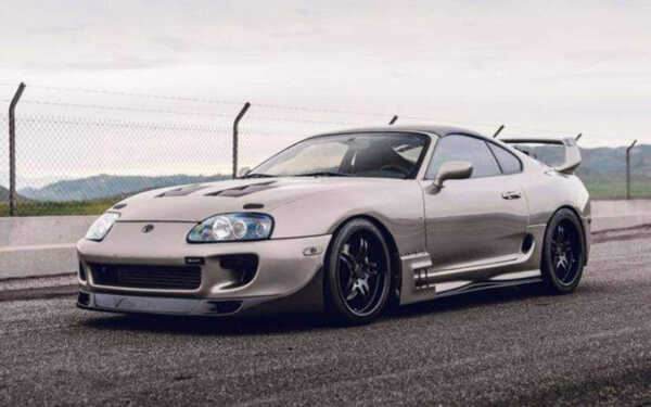 front of a grey Toyota car with moody sky with Syvecs Toyota Supra 1993-2000 - S7I Plug N Play ECU
