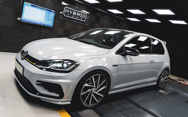 3/4 front shot of white VW Golf R in Hybrid Tune's sound proof dyno cell.