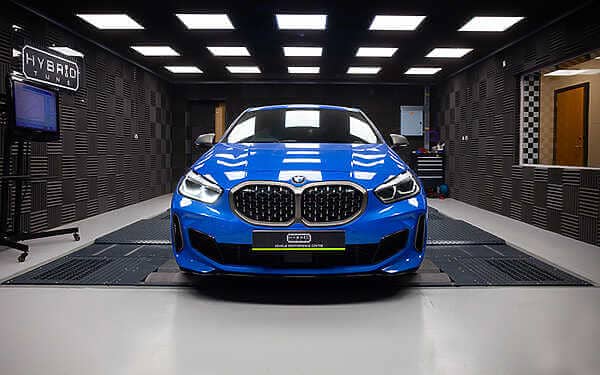 BMW F40 M135i F44 M235i F39 X2 Tuning B48TU Strat-2 Device 355 BHP : 497 NM. Blue F40 M135i front view in Hybrid tune's dark grey dyno cell