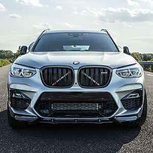 Enhanced BMW F97 X3M tuning to attain an impressive power output of 605+ BHP. Silver hybrid tunes x3m parked in the middle of the road with light clouds in the sky