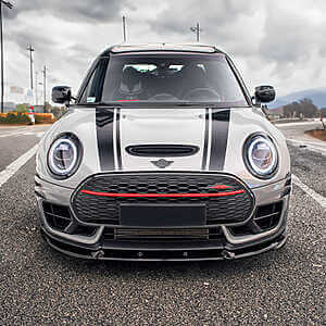 Mini F54 Clubman JCW Tuning B48TU STRAT-2 Device from Hybrid Tune. Front view of a grey mini with black bonnet stripes parked in the road with a moody sky in the background