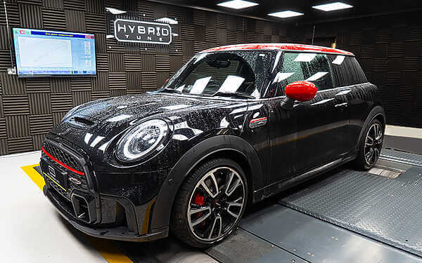 We can now promise real-world, performance increases for the BMW Mini B48 engine of 275+BHP: 378+NM. Side shot of a dark grey mini jcw with a red roof in a dark grey sound proof dyno cell